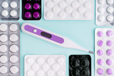 Coronavirus covid-19 outbreak. Tablets in blister, pills, drugs, medicine, vaccine, digital thermometer on blue background. Pharmacy, medicine, healthcare concept. Painkiller, vitamin, antibioticの写真素材