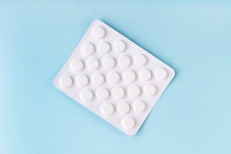 Tablets in blister, pills, drugs, medicine on blue background. Pharmacy, medicine, healthcare concept. Painkiller, vitamin, antibiotic. Coronavirus treatment. Drugstore concept. Tablet overdose.の写真素材