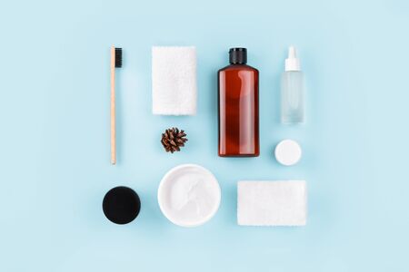 Spa composition on blue background. Wellness layout with towels, bamboo toothbrush, peptide oil, facial or body cream, top view, flat lay. Skin care, body treatment, beauty concept.の写真素材