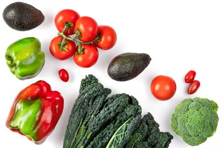 Vegetable composition on white background. Black curly kale, tomatoes, avocado, pepper on white background with copy space. Vegetarian healthy food. Creative layout. Healthy lifestyle conceptの写真素材