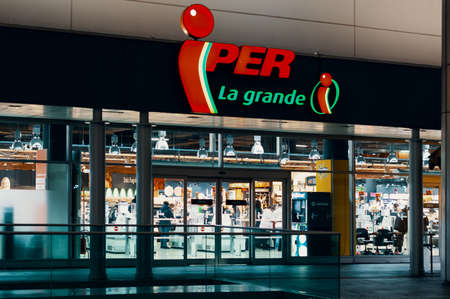 Iper logo and showcase of the store at night. Iper is the brand with which Finiper Spa, operates, a large-scale distribution company. Milan, Italy - 29.12.2019のeditorial素材