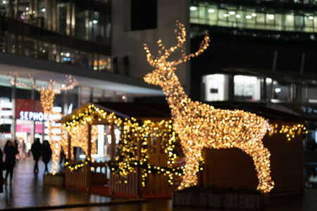 Blurred lights of christmas installation - defocused lights of deer on night city background. Christmas deer installation. Milan, Italy - 25.12.2019のeditorial素材
