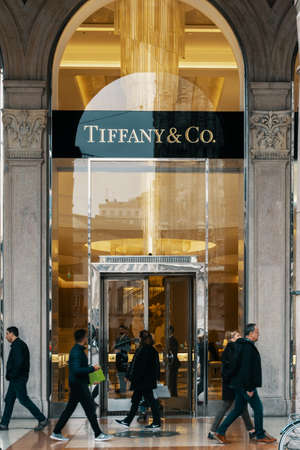 Tiffany and Co logo and exterior of luxury fashion shop in Milan near Duomo. People passing by the store. Milan, Italy - 31.10.2019のeditorial素材