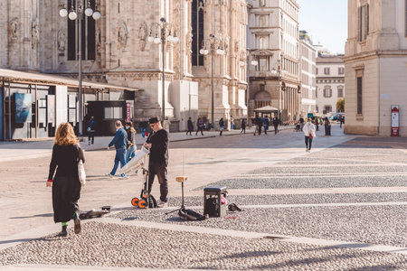 People walking near Duomo cathedral Milan city during coronavirus on a sunny day, Covid 19 outbreak....