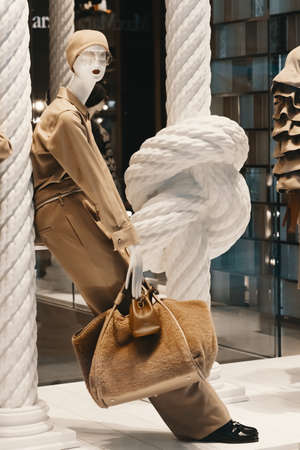 Mannequin standing at showcase of the fashion shop. Luxury fashion boutique storefront exhibition with new winter street collection for stylish women. Modern retail clothing store.の写真素材