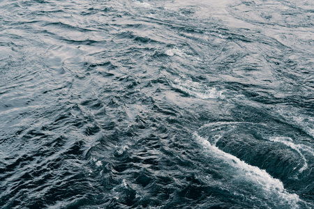 Blue water texture on dark background. Background wallpaper. Shot of aqua sea river water surface