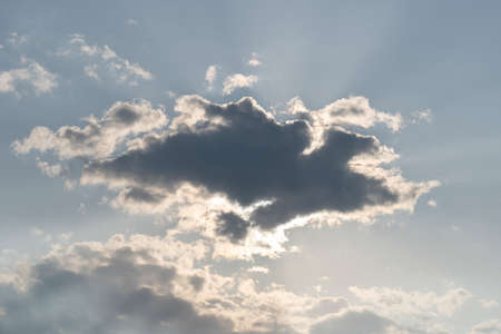 Big grey cloud hiding the sun. Magnificent panoramic cloudscape. Fluffy cumulonimbus cloud on blue sky. Cloudy sky at daytimeの写真素材