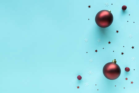 Christmas composition with red bright baubles decorations on pastel blue surface, top view, copy space. Merry Christmas and Happy Holidays greeting card, frame, banner, flat layの写真素材