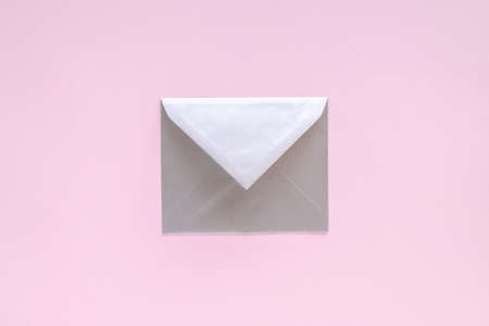 Silver envelope with greeting card on pastel pink background. Letter with congratulations, letter to Santa Claus. Christmas or New Year 2021 minimal concept. View from above, flat layの写真素材