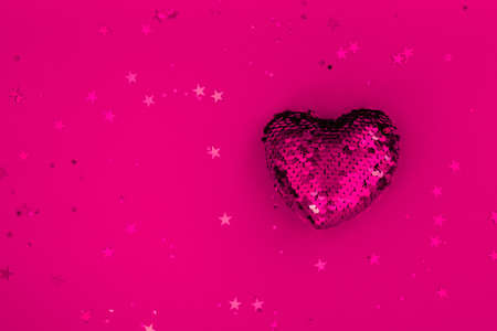 Christmas or Valentines composition made from glowing red heart decoration and glitter on purple surface. Merry christmas and happy 2021 New Year, Happy Valentine concept. Flat lay, top view, bannerの写真素材