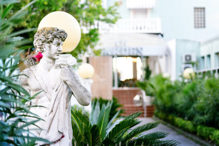 Monument of young man in the hotel territory. Sculpture of man. Outdoor marble statue in summer garden. Gabbice Mare, Italy.の写真素材