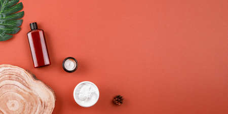 Natural cosmetics on brown surface, skincare mockup products flat lay. Facial cosmetic products layout, top view, banner. Beauty and skin care concept.の写真素材