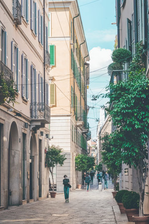 Typical italian narrow street of historic city center on sunny summer day. Cityscape of Milan. People walking along the street. Milan, Italy - September 24, 2020のeditorial素材