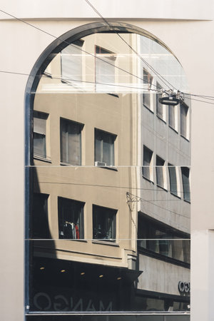 Abstract fragment of old building architecture reflected in modern corporate building. Front view of...