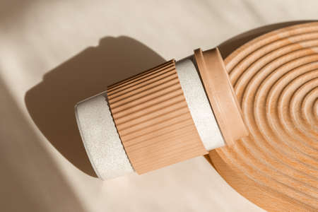 Reusable cup, biodegradable travel plastic coffee mug take away. Bamboo eco friendly cup on natural shadow beige background with wooden decor. Zero waste, sustainability, sustainable lifestyleの写真素材