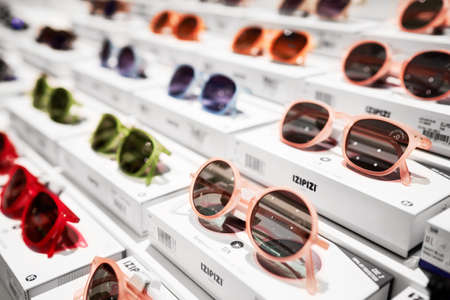 Sunglasses stand on the shop shelf. Sun glasses in Rinascente, collection of high-end stores with Italian and international brands in fashion, accessories, design. Milan, Italy - December 15, 2020のeditorial素材