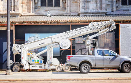 Milan, Italy - July 7, 2020. Car and scissor lift platform with hydraulic system, lifting machine near Duomo in Milan. Duomo cathedral building during reconstructionのeditorial素材