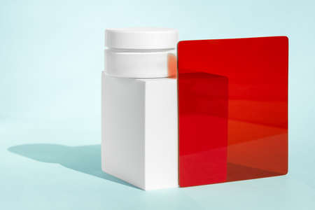 Lotion pot, face mask showcase presentation. Organic science concept, science-based skincare. White cream cosmetic jar mockup on cube geometric pedestal podium with red transparent plateの写真素材
