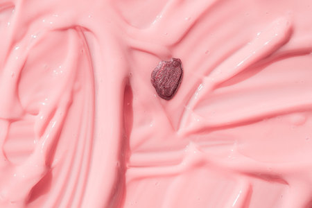Abstract cosmetic textured background, nail polish drop on pink liquid foundation texture. Creamy...