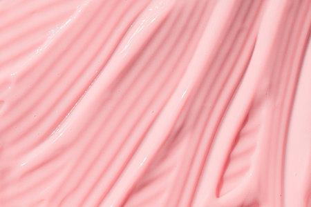 .Creamy pink skincare lotion mousse product closeup. Peach cream, moisturizer, shampoo spread,...