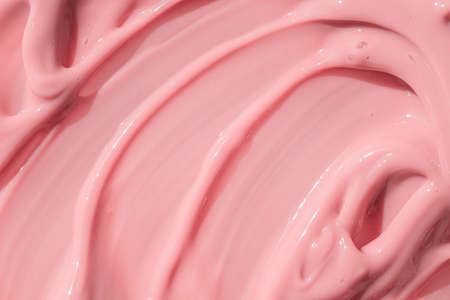 Beauty creme smear background. Pink cosmetic cream lotion moisturizer texture smudge sample. Skin care product strokes closeup. Creamy textured backdrop. Macro, close upの写真素材