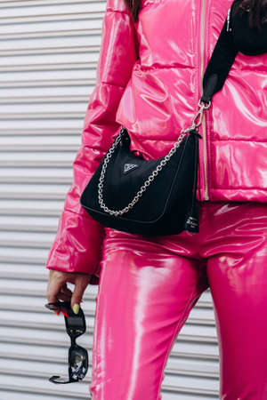 Milan, Italy - September 24, 2021: Street style outfit details, fashionable woman wearing pink jacket and pants latex, Prada bagのeditorial素材