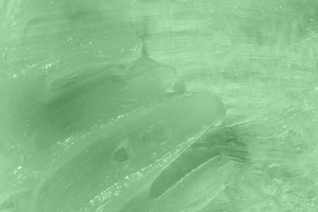 Liquid green balm texture smudge. The concept of natural cosmetics. Homemade beeswax sample. Aloe vera cosmetic gel texture background. Skincare moisturizing product. Close-up, macro.の写真素材