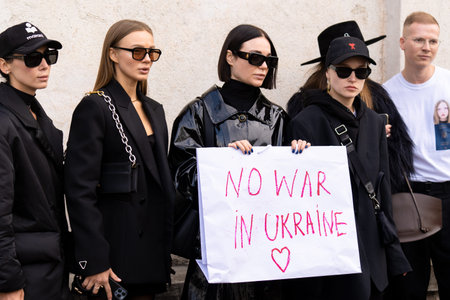 Fashion women hold the poster with the slogan No war in Ukraine and love heart sign as a patriotic...