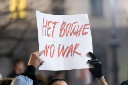 Two hands and the poster above with slogan No War at the meeting on the square Piazza della Scala...