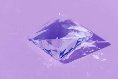 Light spectrum reflected through glass prism. Crystal prism with light diffraction of spectrum colours and reflection with trendy light and hard shadows on lilac background. Bannerの写真素材