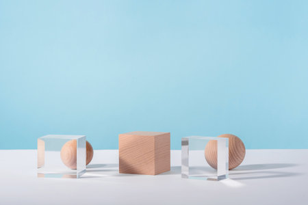 Creative geometric product stage mock up, cosmetics display platform, product advertising, geometric stand. Wooden and glass cube podium, sphere on blue background for cosmetic or jewellery showcaseの写真素材