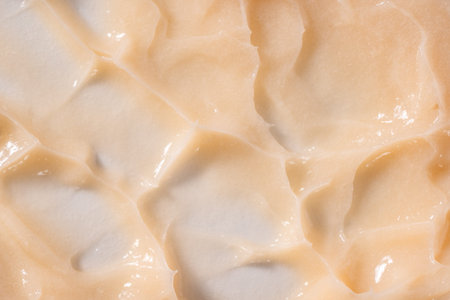 Hair conditioner cream background. Yellow cosmetic lotion moisturiser sample closeup. Body care...