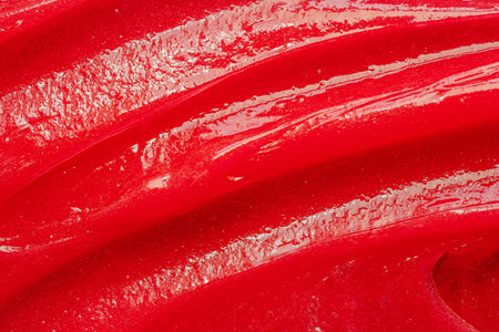 Red gel texture. Cosmetic clear liquid cream smudge. Skin care product sample closeup. Toothpaste or...