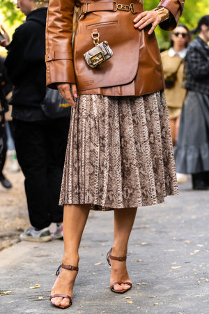 Milan, Italy - September, 21, 2022: woman wearing snake print pattern bag, brown shiny leather...