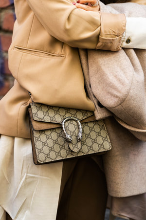 Milan, Italy - September, 21, 2022: woman wearing beige blazer jacket, beige and brown print pattern crossbody Dionysus GG Supreme mini bag from Gucci, beige coat, street style outfit details.のeditorial素材