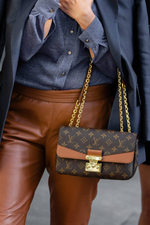 Milan, Italy - September, 22, 2022: woman wears chain crossbody handbag Marceau canvas monogram...