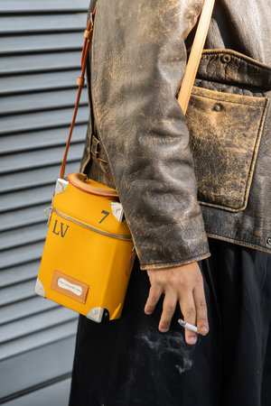 Milan, Italy - September, 22, 2022: man wears vertical box trunk from Louis Vuitton, street style...