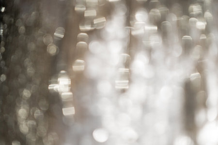 White, silver glitter vintage lights background defocused for festivals and celebrations, abstract bokeh from shining materialの写真素材