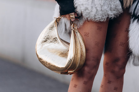 Milan, Italy - February, 27, 2022: woman wears gold metallic leather Fendi Fendigraphy, street style detailsのeditorial素材