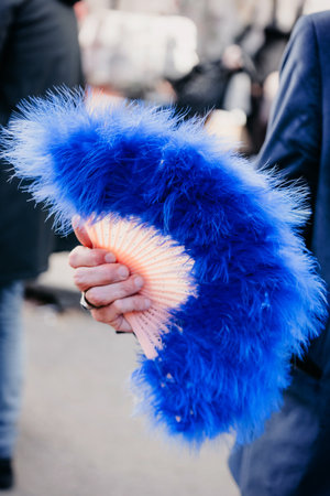 Man is holding feather handmade fan on the streetのeditorial素材