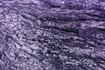 Abstract underwater wallpaper. Aquatic ripple wavy lilac water surface, water texture background, top view.の写真素材