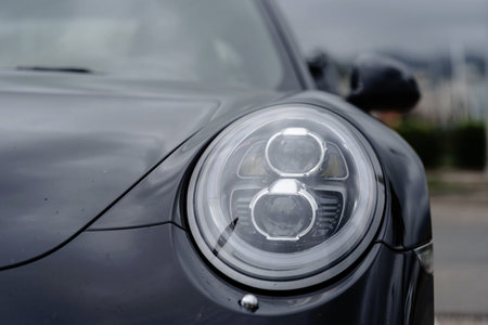 Modern black car xenon lamp headlight, front view close up. Modern car closeup of headlight. Exterior detailの写真素材