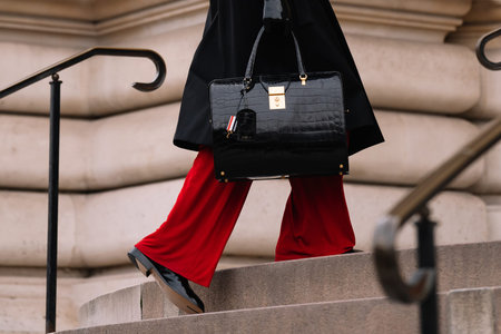 Paris, France - January, 23, 2023: man wears black red pants and Thom Browne alligator bag, street...