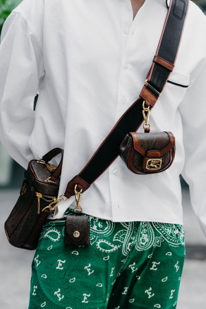Milan, Italy - June, 19, 2022: man wears brown mini paisley shoulder bag from Etro, street style accessories.のeditorial素材