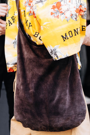 Milan, Italy - June, 19, 2022: man wears italian suede hobo bag from Dazoriginal, menswear street...