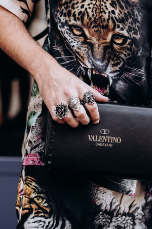 Milan, Italy - June 20, 2022: man wears Valentino Rockstud calfskin pouch, menswear street style...