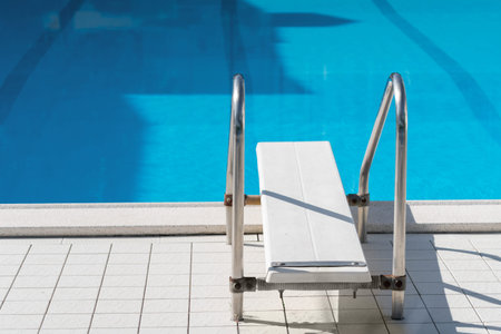 Grab bars ladder in the blue swimming pool