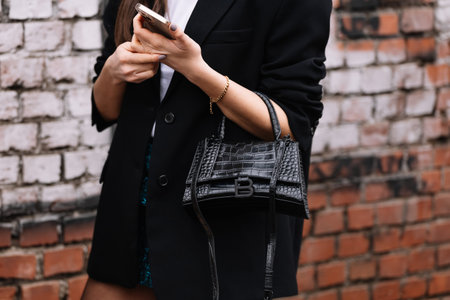 Milan, Italy - February 22, 2023: woman wearing Balenciaga shoulder bag. Fashion blogger outfit...
