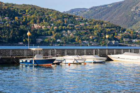 Pier and boats docked at marina on Lake Como in the harbor of the city of Como, Lombardy, Northern Italyの写真素材