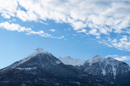 Mountain covered with snow and fog. Alpine landscape in Italy, Europe. Snow-capped mountains against...